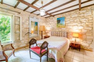 a bedroom with a large bed in a room with stone walls at Van Gogh in Fourques