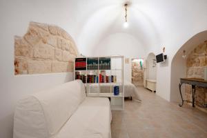 a living room with a white couch and a book shelf at L' Ippocampo in Polignano a Mare +19 photos