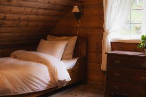 a bed in a wooden room with a window at Aarvik organic farm & bakery in Tveit