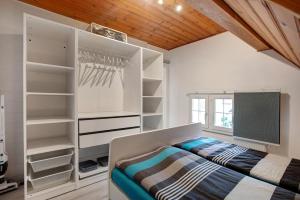 a bedroom with white shelves and a bed at Ferienwohnung Dashaus in Rheinfelden