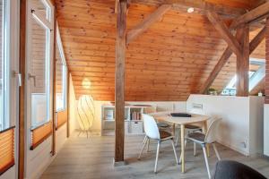 a room with a table and chairs and wooden ceilings at Ferienwohnung Dashaus in Rheinfelden
