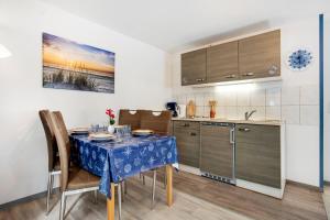 a kitchen with a table with a blue table cloth at Bungalow Mary Ann, Bgl 25 in Dranske +9 photos