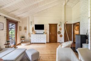 a living room with a tv on a white dresser at Almhütte in Ulrichstein