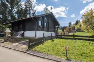 a house on the side of a road with a fence at Almhütte in Ulrichstein