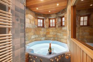 a bathroom with a tub with a bottle of champagne at Ferienwohnung am Steinbach in Albstadt