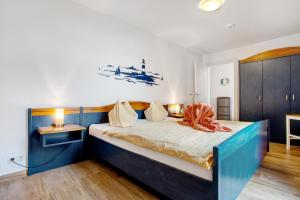 a bedroom with a bed with an orange blanket on it at Ferienwohnung Abendrot 299 in Ueckermünde