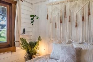 a bedroom with a bed with white curtains and a plant at Almhütte in Ulrichstein
