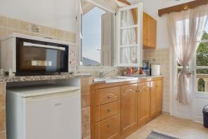 a kitchen with a sink and a microwave at Studio Telendos in Telendos +15 photos