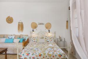 a white bedroom with a bed and a table at Studio Telendos in Telendos