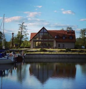 a house on the water with boats in it at Mazurska Oaza in Pisz