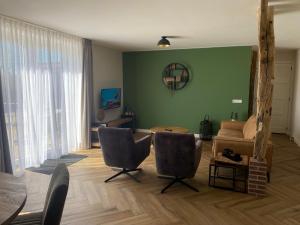 a living room with a couch and a table and chairs at Vakantiewoning Op de Woerd in Aalten