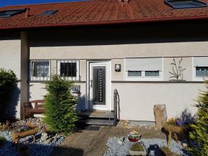 a white house with a door and a bench at Die Wohnung Stein in Bretzfeld
