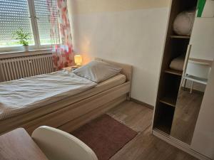 a small bedroom with a bed and a window at Die Wohnung Stein in Bretzfeld