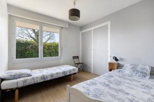 a bedroom with two beds and a window at Le Gîte du Château Saint Ahon in Blanquefort