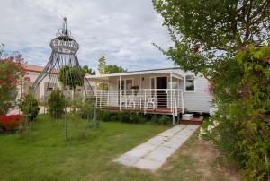 a white house with a bird cage in the yard at Agricamping Ca' Bodi Veneto in Cavallino-Treporti