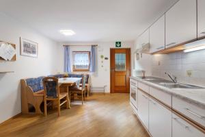 a kitchen and dining room with a table and chairs at Mattleitenhof in Santa Maddalena