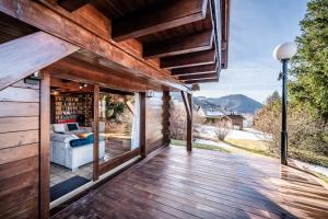 a wooden deck with a view of a house at Chalet Des Charmes in Thollon