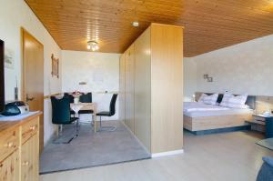 a room with a bed and a table and a bed at Enderle in Uhldingen-Mühlhofen