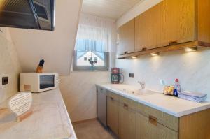 a small kitchen with a sink and a microwave at Enderle in Uhldingen-Mühlhofen