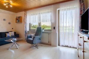 a living room with a chair and a window at Enderle in Uhldingen-Mühlhofen