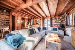 a living room with a couch and a table at Chalet Des Charmes in Thollon