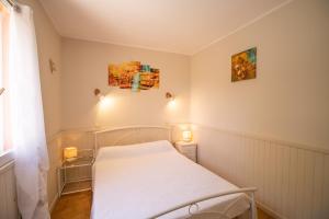 a small bedroom with a white bed and a window at Isula Paradise in Linguizzetta