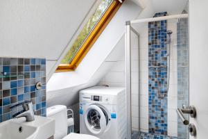 a bathroom with a washing machine and a washer at Bootshaus Am Müritzarm in Vipperow