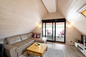 a living room with a couch and a table at Bootshaus Am Müritzarm in Vipperow