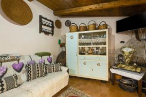 a living room with a couch and a cabinet with wine glasses at Antica dimora in Paulilatino +13 photos