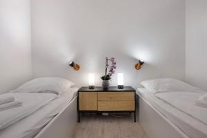 two beds in a room with a table with two candles at Harz Stube in Goslar