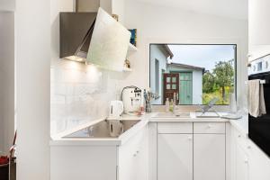 a white kitchen with two sinks and a window at Dahlienhof in Wittenberge +18 photos