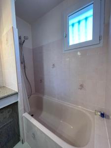 a bath tub in a bathroom with a window at La Maison sur la côte in Fleury +35 photos