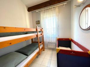 a room with two bunk beds and a window at La Maison sur la côte in Fleury