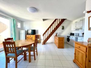 a kitchen with a table and chairs and a staircase at La Maison sur la côte in Fleury
