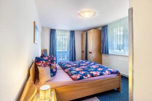 a small bedroom with a bed with colorful pillows at Haus Monika in Todtmoos