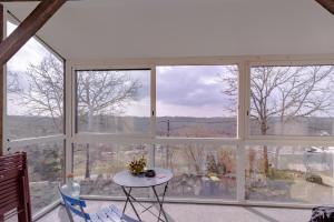 a room with large windows and a white table and chairs at Maison Sur le Causse Corrézien in Saint-Cernin-de-Larche +12 photos
