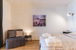 a room with two beds and a chair and a picture on the wall at Wellness Lodge Diletta in Santa Giuliana