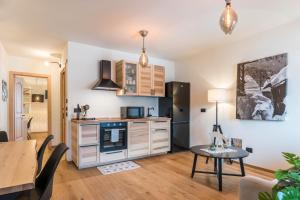 a kitchen and dining room with a table and a refrigerator at Wellness Lodge Diletta in Santa Giuliana