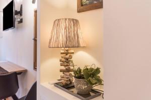 a lamp sitting on a table with a plant at Wellness Lodge Diletta in Santa Giuliana