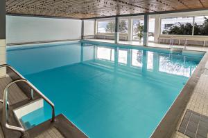 a large swimming pool with blue water at Appartement Förster in Oy-Mittelberg