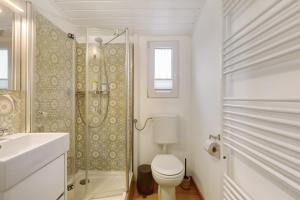 a white bathroom with a toilet and a shower at Tiny House im Grünen in Jesberg +31 photos
