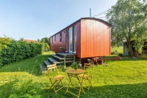 a table and chairs in front of a red shed at Tiny House im Grünen in Jesberg