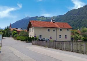 a house with a fence next to a road at Apart Bergtraum Ried - Typ 1 in Ried im Oberinntal