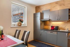 a kitchen with a table and a refrigerator at Apart Bergtraum Ried - Typ 1 in Ried im Oberinntal
