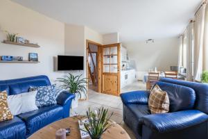 a living room with blue couches and a table at Bi uns to hus - Morgensünn in Nordstrand