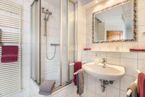 a bathroom with a sink and a shower and a mirror at Bi uns to hus - Morgensünn in Nordstrand +17 photos