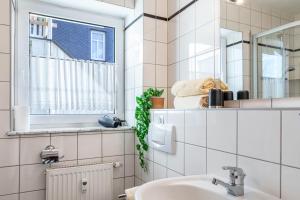 a bathroom with a sink and a mirror at Ferienwohnung Tannenblick 1-1 in Oberhof +16 photos