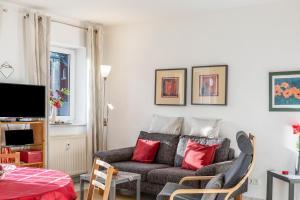 a living room with a gray couch and red pillows at Ferienwohnung Tannenblick 1-1 in Oberhof