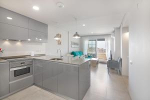 a kitchen with white appliances and a living room at Apartamento en Isla Canela in Ayamonte