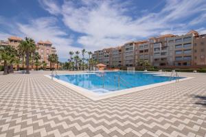 a swimming pool at a resort with buildings at Apartamento en Isla Canela in Ayamonte
